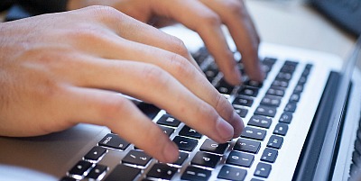Photo of hands typing on a keyboard
